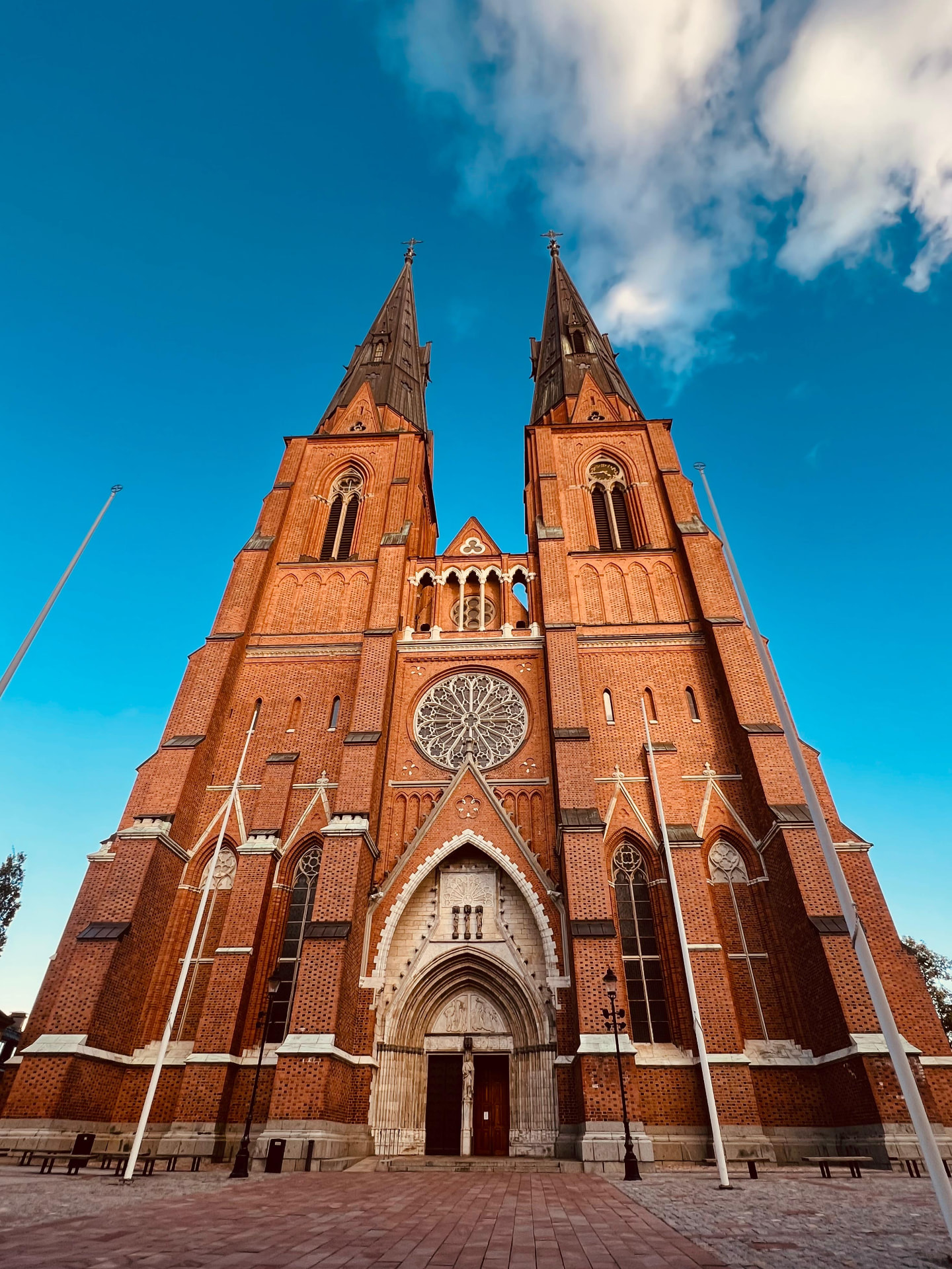 Catedral de tijolos vermelhos fotografada de baixo para cima contra céu azul